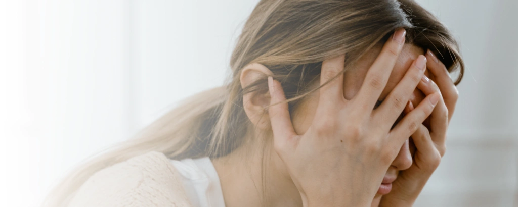 Frau fasst sich verzweifelt ins Gesicht