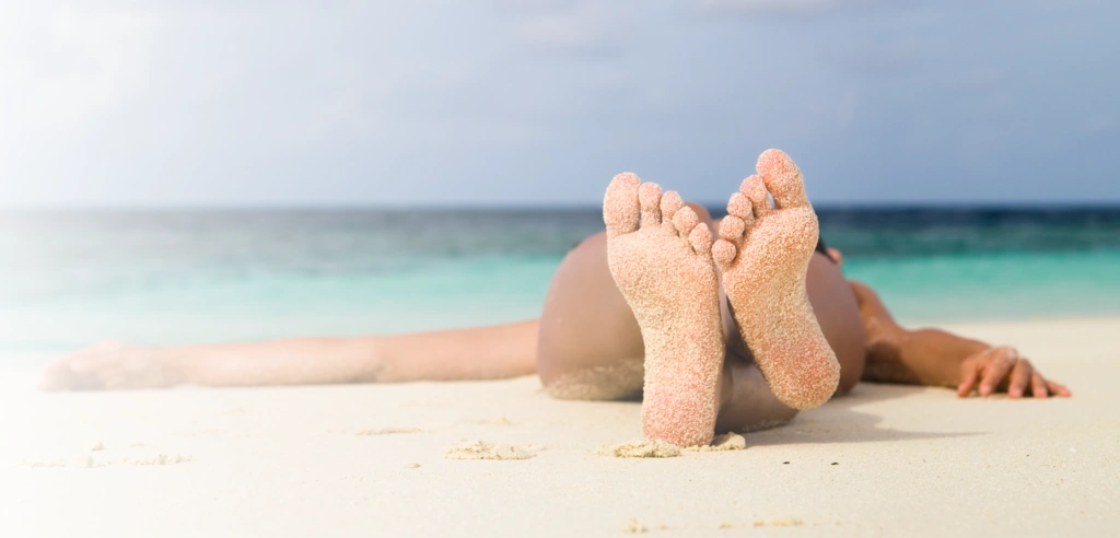 Frau liegt am Strand