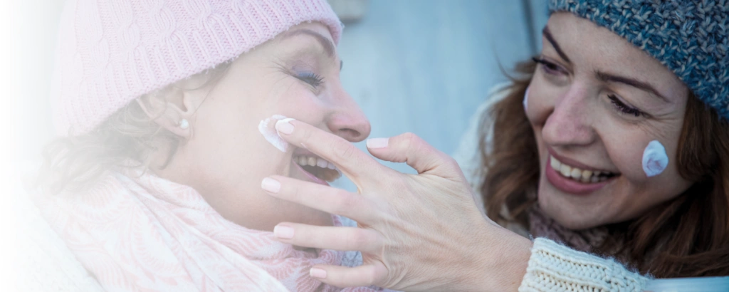 Frauen cremen sich ein im Winter